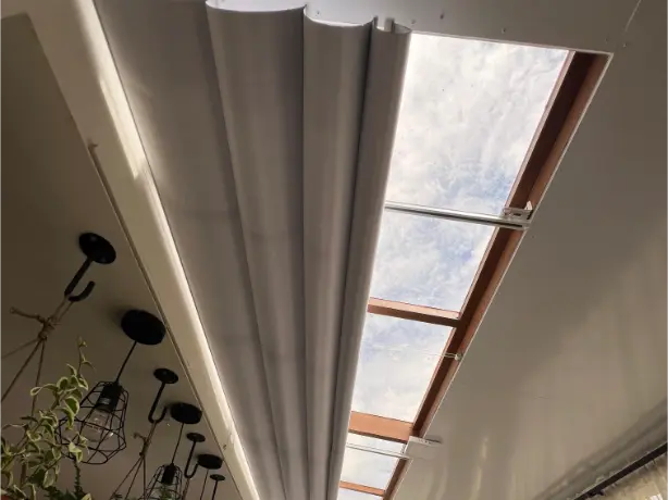 Cortina claraboya gris con control manual en salón