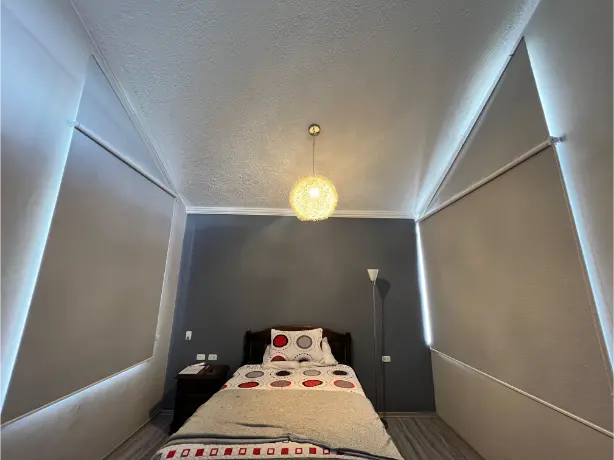 Persiana blackout blanca en habitación con dos ventanas